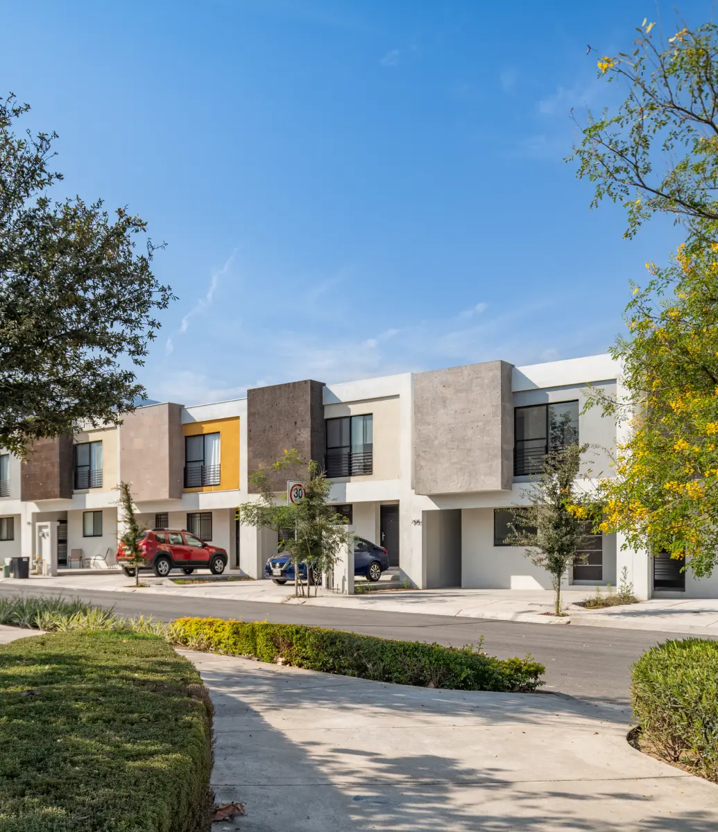 Calzada de parque con casas al fondo